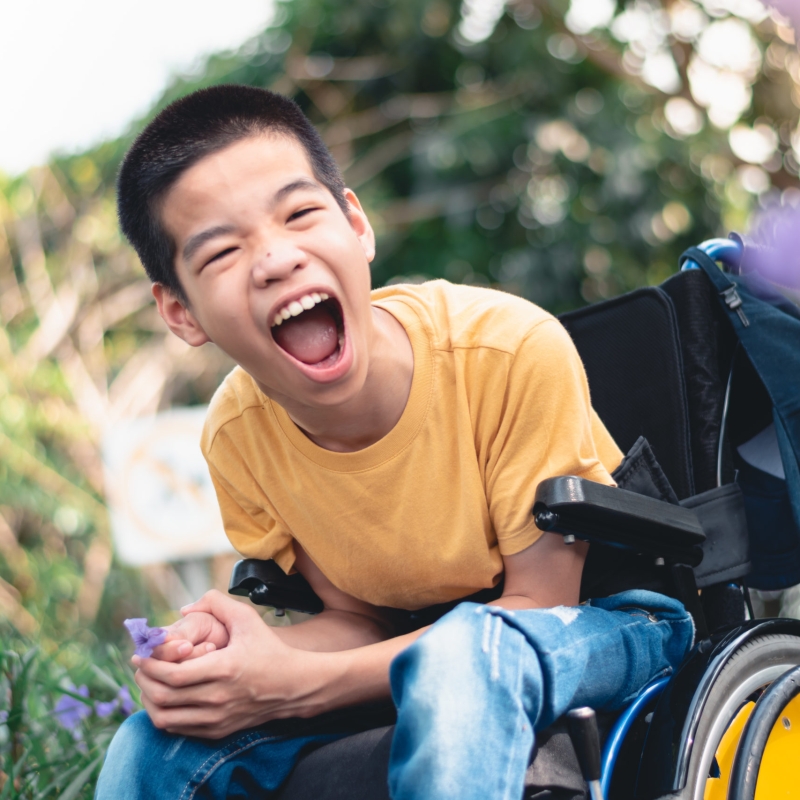 Disabled child on wheelchair is playing, learning and exercise in the outdoor city park like other people,Lifestyle of special child,Life in the education age of children,Happy disability kid concept.